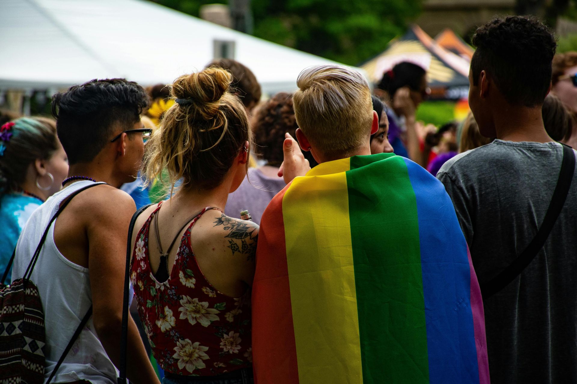A festive crowd celebrating LGBTQ pride with vibrant rainbow colors and lively atmosphere.