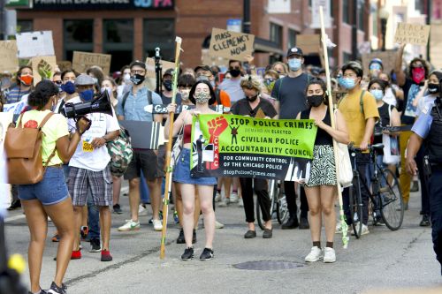Protesters in Chicago demand police accountability in a peaceful march. Participants hold signs and banners.
